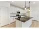 Modern kitchen with white cabinets, granite island, and LVP flooring at 20690 E 58Th Ave, Aurora, CO 80019