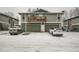 View of the condo featuring a wood balcony above the garage on a snowy day at 10001 E Evans Ave # 81C, Aurora, CO 80247