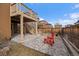 Cozy backyard patio with red chairs, adjacent to a well-maintained lawn and fenced yard at 11828 Churchfield St, Parker, CO 80134