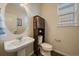 Half bathroom with a pedestal sink, toilet, and storage cabinet at 11828 Churchfield St, Parker, CO 80134