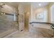 Luxurious bathroom featuring a standalone shower, soaking tub with tile surround, and heated towel rack at 11828 Churchfield St, Parker, CO 80134