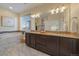 This spacious bathroom features double sinks, granite countertops, and mosaic tile accents around the soaking tub at 11828 Churchfield St, Parker, CO 80134