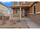 Inviting front porch with stone accents, columns, and manicured landscaping leading to the home's entrance at 11828 Churchfield St, Parker, CO 80134