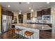 A kitchen with a stainless steel refrigerator, granite counters, and an island with seating at 11828 Churchfield St, Parker, CO 80134