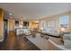 Bright living room featuring hardwood floors, a white sofa, and seamless access to the kitchen at 11828 Churchfield St, Parker, CO 80134