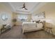 A well-lit main bedroom features plush carpet, large window, and tray ceiling with a ceiling fan at 11828 Churchfield St, Parker, CO 80134