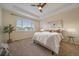 A well-lit main bedroom features plush carpet, large window, and tray ceiling with a ceiling fan at 11828 Churchfield St, Parker, CO 80134