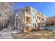 Tan three-story building with multiple balconies and walkway at 979 S Miller St # 202, Lakewood, CO 80226