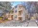 Beige multi-unit building with walkway and trees at 979 S Miller St # 202, Lakewood, CO 80226