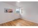 Bright bedroom featuring hardwood floors, a modern painting, a window, and built in shelves at 1270 Elmira St, Aurora, CO 80010
