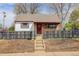 Charming single-story home featuring a stone and white facade, complemented by a black horizontal slat fence at 1270 Elmira St, Aurora, CO 80010