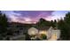 Charming home with a cozy porch and well-lit windows, set against a backdrop of a colorful sunset sky at 116 N Gilbert St, Castle Rock, CO 80104