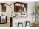 Bright kitchen features stainless steel appliances, granite counters, breakfast bar with seating, and dark wood cabinets at 116 N Gilbert St, Castle Rock, CO 80104