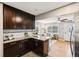 Modern kitchen with dark wood cabinets, granite countertops, stainless appliances, and an open view to the living room at 116 N Gilbert St, Castle Rock, CO 80104