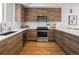 Well-equipped kitchen with modern stainless steel appliances, sleek countertops and wood cabinets at 1810 Irving St # 8, Denver, CO 80204