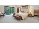 Bright bedroom with natural light, a walkout balcony, a leather bench, and neutral decor at 1298 Meadow View Dr, Evergreen, CO 80439