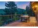 Cozy outdoor deck area with a table and chair set, overlooking a beautiful forest at 1298 Meadow View Dr, Evergreen, CO 80439