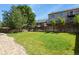 Expansive backyard featuring a lush lawn, a wooden fence, and a stone border, ideal for relaxation at 9860 Burberry Way, Highlands Ranch, CO 80129