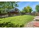 Large, fenced backyard with a well-maintained lawn and a wooden deck, perfect for outdoor activities at 9860 Burberry Way, Highlands Ranch, CO 80129