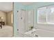 Bright bathroom featuring a glass-enclosed shower, soaking tub, and neutral finishes at 9860 Burberry Way, Highlands Ranch, CO 80129