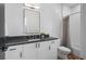 Modern bathroom featuring a white vanity with black countertop, and shower with white tiling at 3285 Lawrence St, Denver, CO 80205