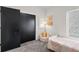 Comfortable bedroom with a plush chair, black closet doors and sunny window at 3285 Lawrence St, Denver, CO 80205