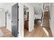 Bright hallway leads to a modern powder room, kitchen, and stairs with sleek black iron railing at 3285 Lawrence St, Denver, CO 80205