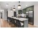 Modern kitchen features a large island with seating, stainless steel appliances, and green cabinets at 3285 Lawrence St, Denver, CO 80205