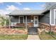 Charming home featuring a covered front porch with swing and brick accents at 4595 S Fox St, Englewood, CO 80110