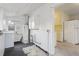 Laundry area featuring hot water tank and white washer with view into the kitchen at 4595 S Fox St, Englewood, CO 80110