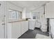 Functional laundry room with washer, dryer, hot water tank, and storage cabinets at 4595 S Fox St, Englewood, CO 80110