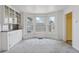 Sunlit living room featuring a bay window and built-in cabinets with glass doors at 4595 S Fox St, Englewood, CO 80110