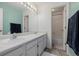 Bright bathroom featuring double sinks, white cabinets, and tile-surround tub at 9275 Erminedale Dr, Lone Tree, CO 80124