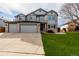 Two-story home showing a well-maintained lawn and a spacious three car driveway at 9275 Erminedale Dr, Lone Tree, CO 80124