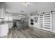 Kitchen area with white cabinets, a gray island, pendant lights, stainless appliances, and a sliding barn door at 9275 Erminedale Dr, Lone Tree, CO 80124