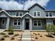 Inviting exterior of gray townhouse with stylish entryway and landscaped front yard with stone details and concrete steps at 17137 W 91St Ln, Arvada, CO 80007