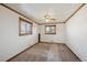 Bright bedroom with neutral carpet, wood trim, ceiling fan, and two windows at 11782 Gilpin St, Northglenn, CO 80233