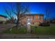 Charming brick home exterior with manicured lawn and mature trees at dusk at 11782 Gilpin St, Northglenn, CO 80233