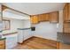 Kitchen featuring a breakfast bar and wood cabinets with a partial view of the living room at 11782 Gilpin St, Northglenn, CO 80233