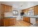 Bright kitchen with hardwood floors, wood cabinets, and white appliances at 11782 Gilpin St, Northglenn, CO 80233