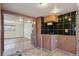 Basement kitchenette featuring a sink, dark backsplash, and decorative cabinetry at 11782 Gilpin St, Northglenn, CO 80233