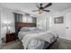 Main bedroom with ceiling fan, large bed, and ensuite bathroom at 1040 S Fulton Ave, Fort Lupton, CO 80621