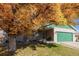 Brick ranch home with a green garage door and autumn leaves at 1040 S Fulton Ave, Fort Lupton, CO 80621