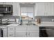 Clean white kitchen with stainless steel appliances and a window at 1040 S Fulton Ave, Fort Lupton, CO 80621