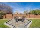 Stone patio with fire pit and seating area in backyard at 1040 S Fulton Ave, Fort Lupton, CO 80621