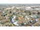 Aerial view of townhomes in a snow-covered community near commercial buildings and generous parking at 9183 W Cedar Dr # 2, Lakewood, CO 80226