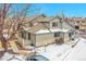 Charming townhome with snow, bare tree, and a well-maintained lawn at 9183 W Cedar Dr # 2, Lakewood, CO 80226