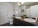 Bathroom with double sinks, dark wood cabinets, a toilet, and white doors on the left at 14300 Waterside Ln # S2, Broomfield, CO 80023