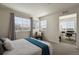 Bright bedroom showing a full bed, a study with a modern desk and chair, and natural light from the windows at 14300 Waterside Ln # S2, Broomfield, CO 80023