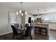 Open dining area featuring a modern chandelier, dark wood floors, and views into the kitchen at 14300 Waterside Ln # S2, Broomfield, CO 80023